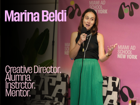 Keynote speaker Marina Beldi speaking into a microphone in front of a Miami Ad School New York backdrop, with on-screen text reading "Creative Director. Alumni. Instructor. Mentor."
