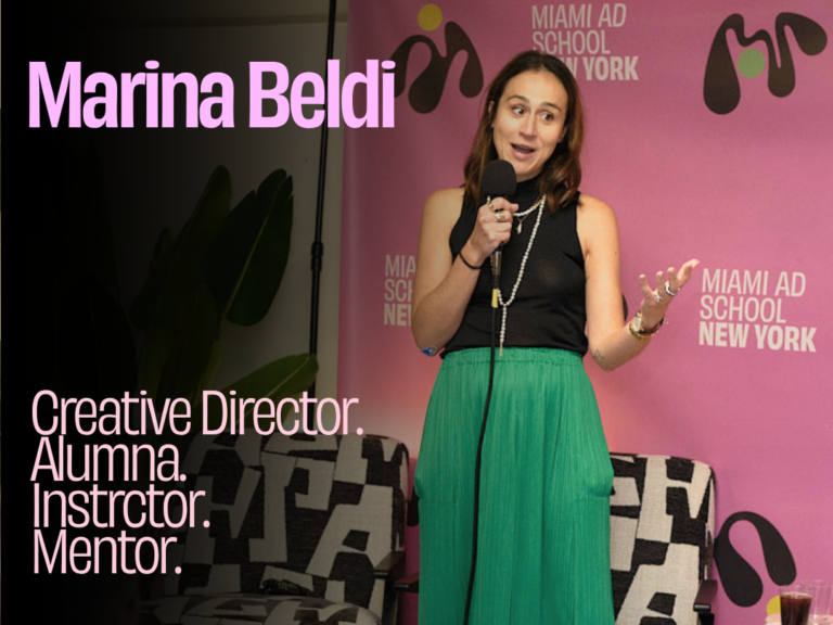 Keynote speaker Marina Beldi speaking into a microphone in front of a Miami Ad School New York backdrop, with on-screen text reading "Creative Director. Alumni. Instructor. Mentor."